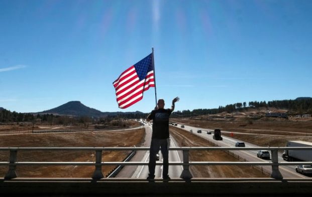 Civics in America. A holds a flag.